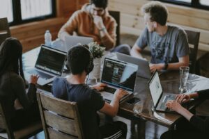 Software development team collaborating on laptops